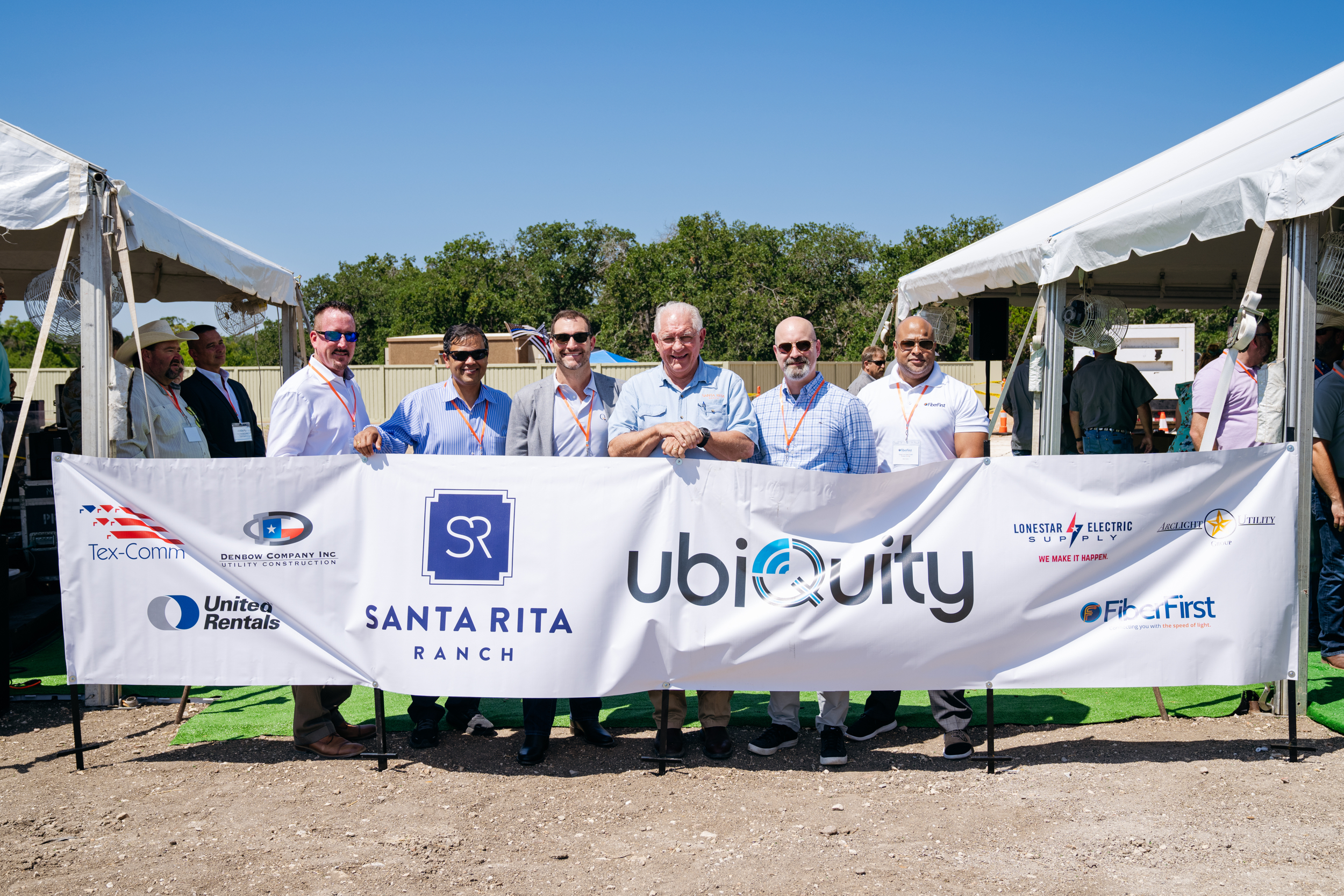 Ubiquity employees holding a banner